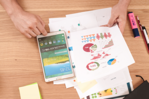 Papers and iPad on desk that contain data for marketing strategy