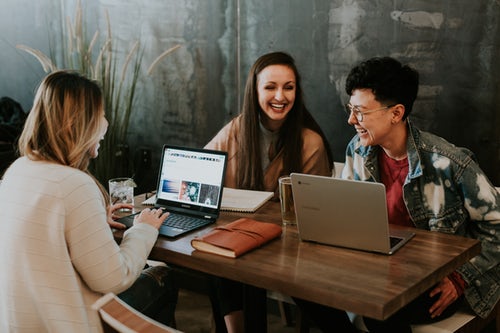 Three colleagues sit round a coffee table discussing their marketing strategy